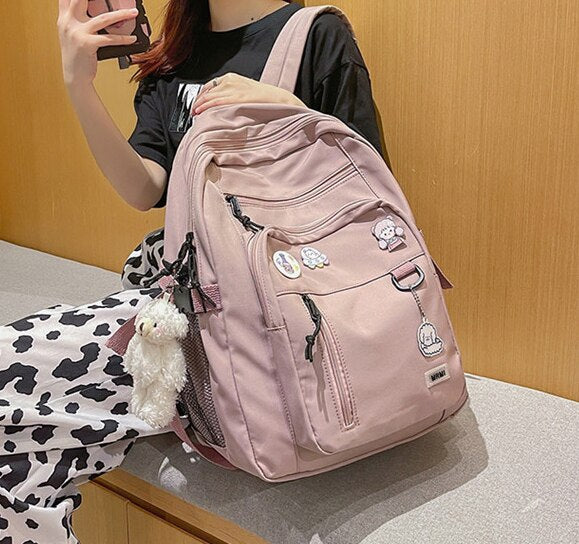 Duży plecak szkolny z brelokiem i ozdobnymi przypinkami