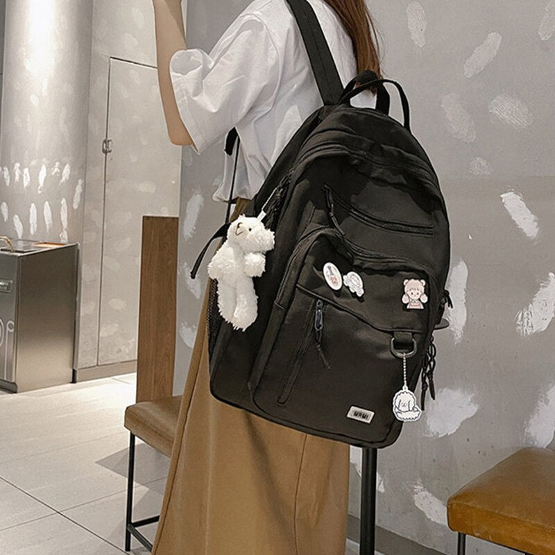 Duży plecak szkolny z brelokiem i ozdobnymi przypinkami